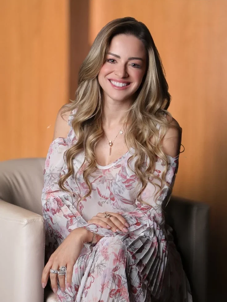 Dra. Maria Isabel Tom Back sorrindo, sentada em uma poltrona
